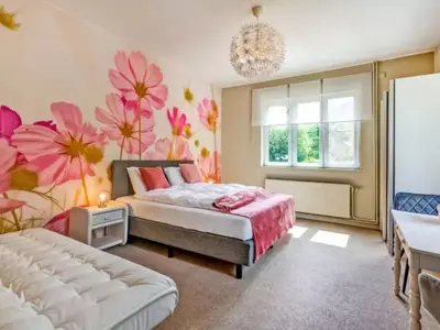 a bedroom with two beds and flowers on the wall at Alterbiezen in Hoeselt