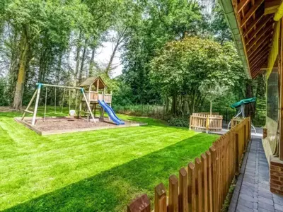 a yard with a playground and a fence at Alterbiezen in Hoeselt