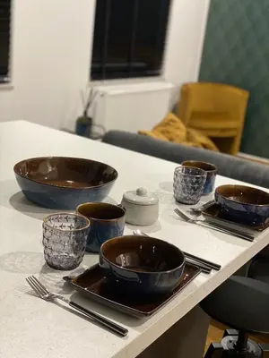 a table with bowls and utensils on it at Cozy apt w/ king bed great for discovering Liege in Liège