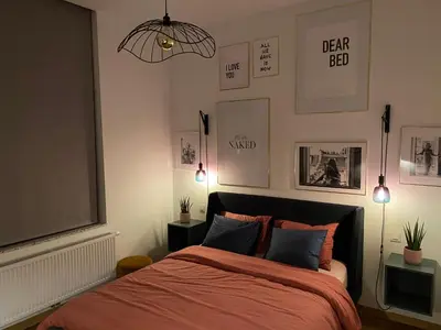 a bedroom with a bed with a red comforter at Cozy apt w/ king bed great for discovering Liege in Liège