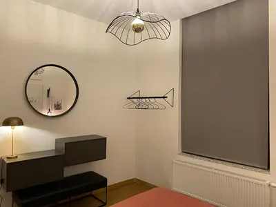 a living room with a mirror and a chair at Cozy apt w/ king bed great for discovering Liege in Liège