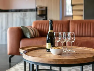 a bottle of wine and three wine glasses on a table at Ons Huis in Hechtel-Eksel