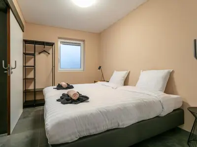 a bedroom with a large bed with a baby on it at Ons Huis in Hechtel-Eksel