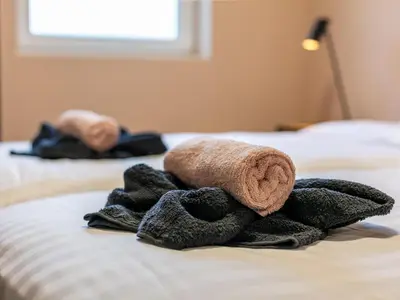 a pile of towels sitting on top of a bed at Ons Huis in Hechtel-Eksel