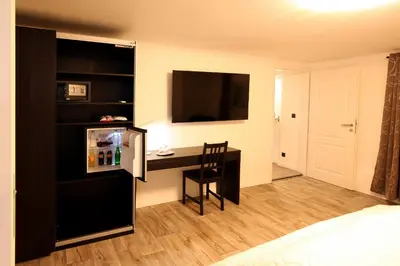 a small room with a desk and a refrigerator at Marias Guest House in Eynatten