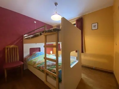 a bedroom with two bunk beds and a chair at Drieskenshoeve in Grote-Brogel
