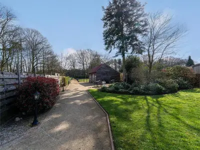 a garden with a path and a tree and a building at De Kievelder in Peer
