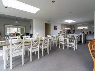 a dining room with white tables and white chairs at Secretarishuis in Peer