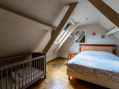 a attic bedroom with a bed and a window at Het Bruegelhof in Peer