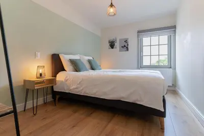 a bedroom with a large bed and a window at Vakantiewoning Mèzik in Maasmechelen