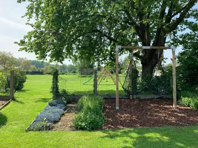 a garden with a swing and a tree at Vakantiewoning Mèzik in Maasmechelen