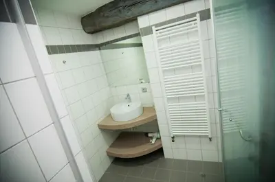 a bathroom with a sink and a white window at Apartment De Maasnacht in Maaseik