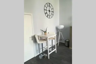 a room with a table and a clock on the wall at Duplex 90m Centre Verviers Calme Gare à pied Spa Francorchamps 20 min in Verviers
