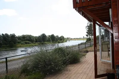 a building with a view of a river with a boat in it at Viva La Vie in Maaseik