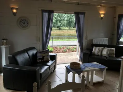 a living room with a leather couch and a table at Viva La Vie in Maaseik