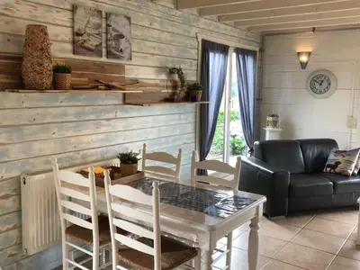 a dining room with a table and a couch at Viva La Vie in Maaseik