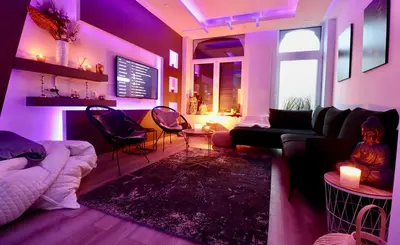a living room with purple lighting and a couch and chairs at SuiteDreams - Bubble Suite Liège in Liège