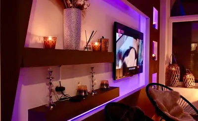 a room with a tv and a table with chairs at SuiteDreams - Bubble Suite Liège in Liège