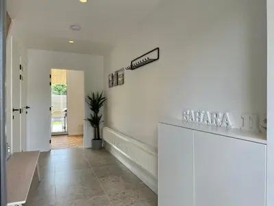 a hallway with white walls and a sign on the wall at Vakantiehuis Sahara119 in Lommel
