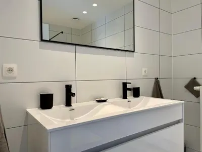 a white bathroom with a sink and a mirror at Vakantiehuis Sahara119 in Lommel