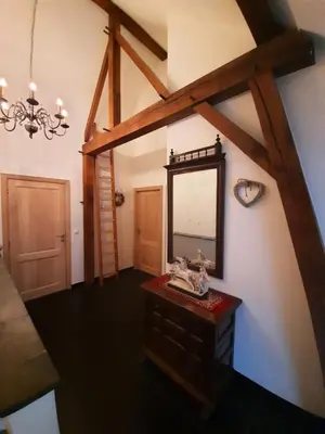an attic room with a mirror and a table at Hof van Eggertingen nr. 8 in Riemst