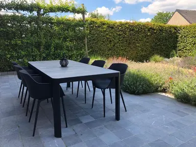 a black dining table and chairs on a patio at Hof van Eggertingen nr. 8 in Riemst