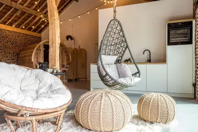 a room with two chairs and a hammock at De Hoeveschuur in Riemst
