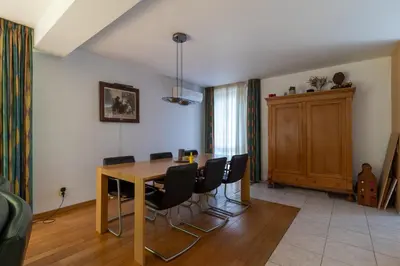 a dining room with a wooden table and black chairs at Vakantiehuis Salamander Maasmechelen in Maasmechelen