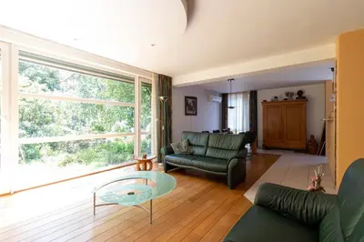 a living room with a couch and a glass table at Vakantiehuis Salamander Maasmechelen in Maasmechelen