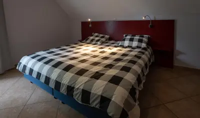a bed with two pillows on it in a room at Logement de Blauwe Reiger in Voeren