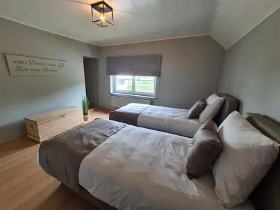 a bedroom with two beds and a window at Prinsheerlyck in As