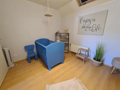 a living room with a blue crib and chairs at Prinsheerlyck in As