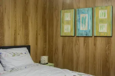 a bedroom with a bed with three pictures on the wall at 'T ONDERDAK in Lommel