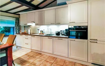 a kitchen with white cabinets and a black appliance at Stunning Home In Meeuwen-Gruitrode in Aan ʼt Hoolven