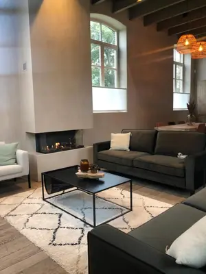a living room with a couch and a fireplace at Factorij10 in Peer