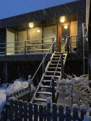 a set of stairs in front of a house in the snow at Le Petit Logis in Jalhay