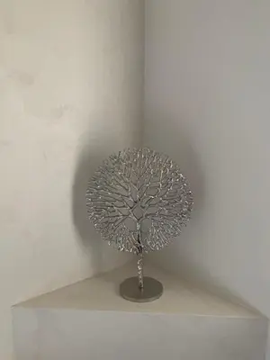 a silver tree lamp sitting on a white wall at B&B elzartwinning in Hasselt