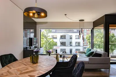 a living room with a table and a couch at Boulevard Botanie city apartment with parking in Hasselt