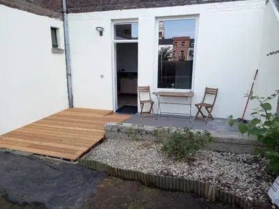 a porch with two chairs and a table on a house at Patenier Hidden Garden 1bdr with garden in Liège