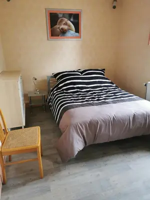 a bed in a bedroom with a picture of a dog at Ferienwohnung in einem alten Bauernhaus in Lontzen