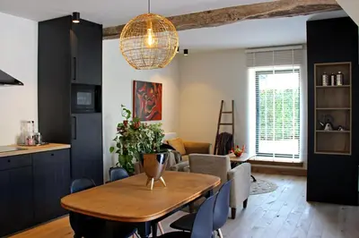a kitchen and dining room with a table and chairs at Het Koerhuis in Kinrooi