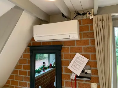a air conditioner in a room with a brick wall at La Casita E41 in Lanaken