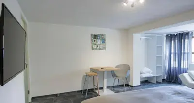 a bedroom with a bed and a table and chairs at Grey House in Olne