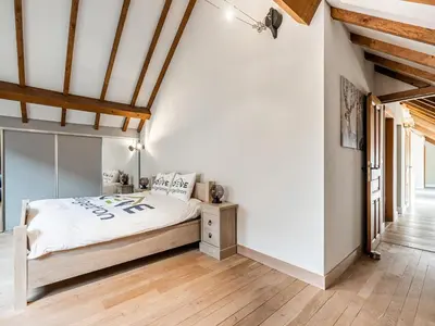 a bedroom with white walls and a bed with a wooden floor at Alken Farm Stay with Terrace in Alken