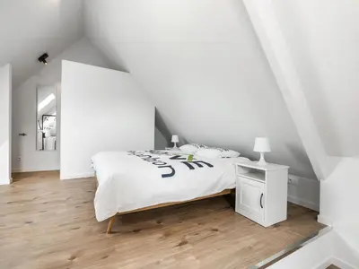 a white bedroom with a bed and a wooden floor at Alken Farm Stay with Terrace in Alken