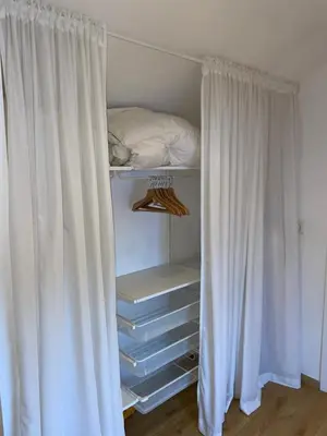 a closet with white curtains and a bed in it at L'Entre-Temps in Xhendelesse