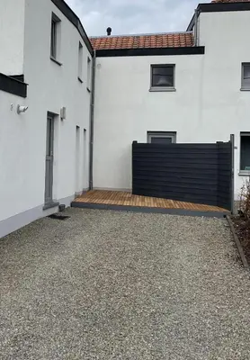 a white house with a black fence and a driveway at L'Entre-Temps in Xhendelesse