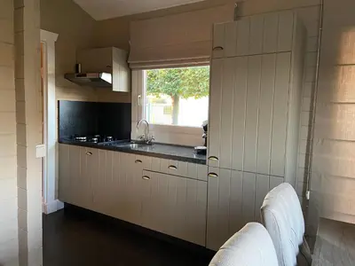 a kitchen with a sink and a window at Chalet Eau Vive Meinekom in Maaseik