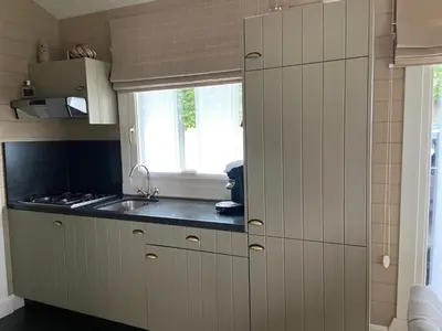 a kitchen with a sink and a window at Chalet Eau Vive Meinekom in Maaseik