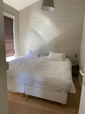 a white bed in a room with a window at Chalet Eau Vive Meinekom in Maaseik